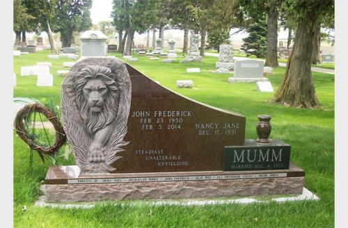 Upright monument with engraved lion and vase