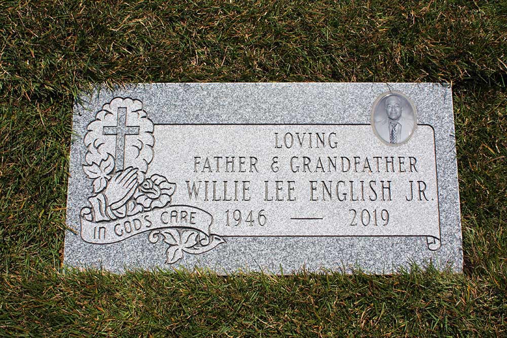 Grey granite marker with cross praying hands and a ceramic photo