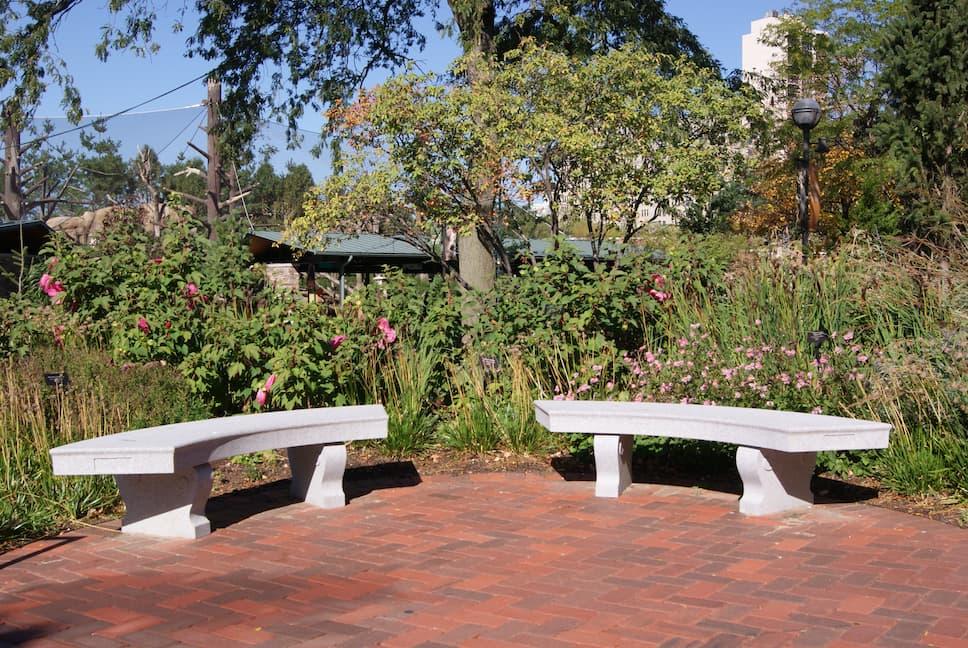 Grey granite benches beside Lincoln Park greenery