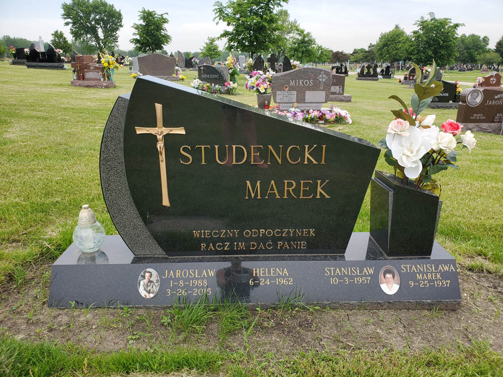 Family monument in black granite with bronze cross and Polish lettering