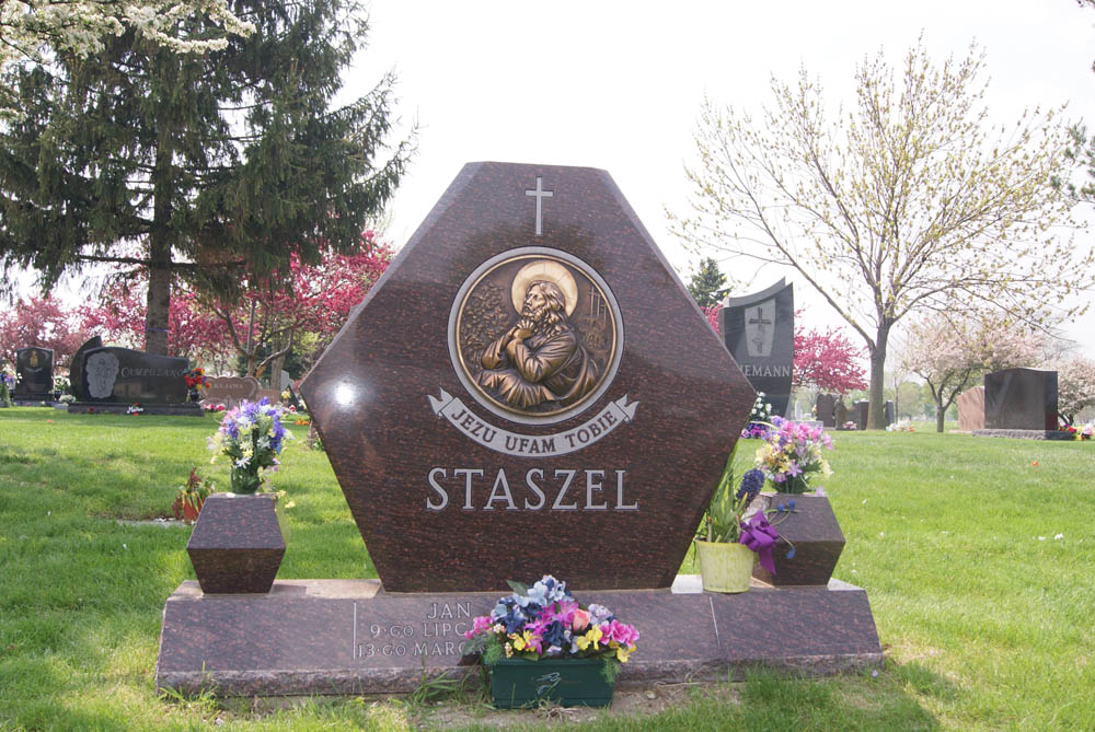 Family monument in brown granite with bronze image of Jesus
