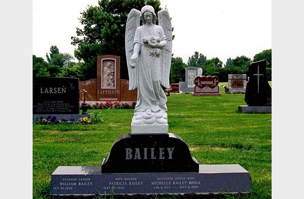 Family monument with a statue of an angel on a black granite pedestal