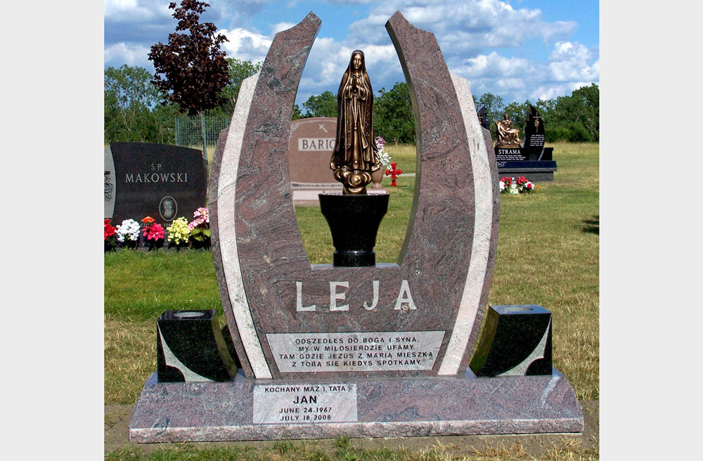 Family monument in violet granite with bronze statue of Mary and Polish text