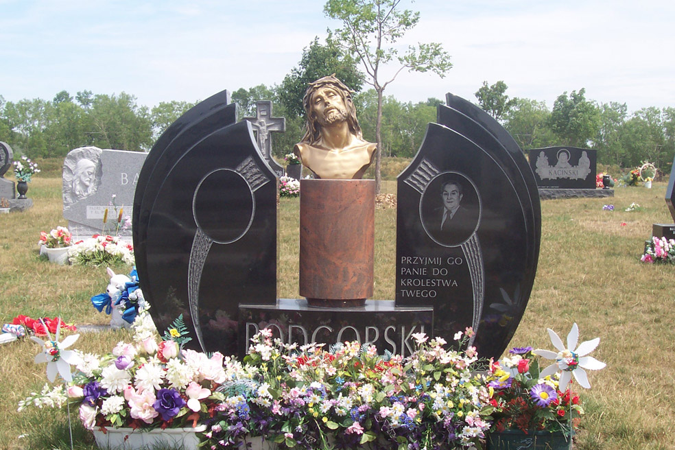 Winged two grave monument in black granite with bronze bust of Christ